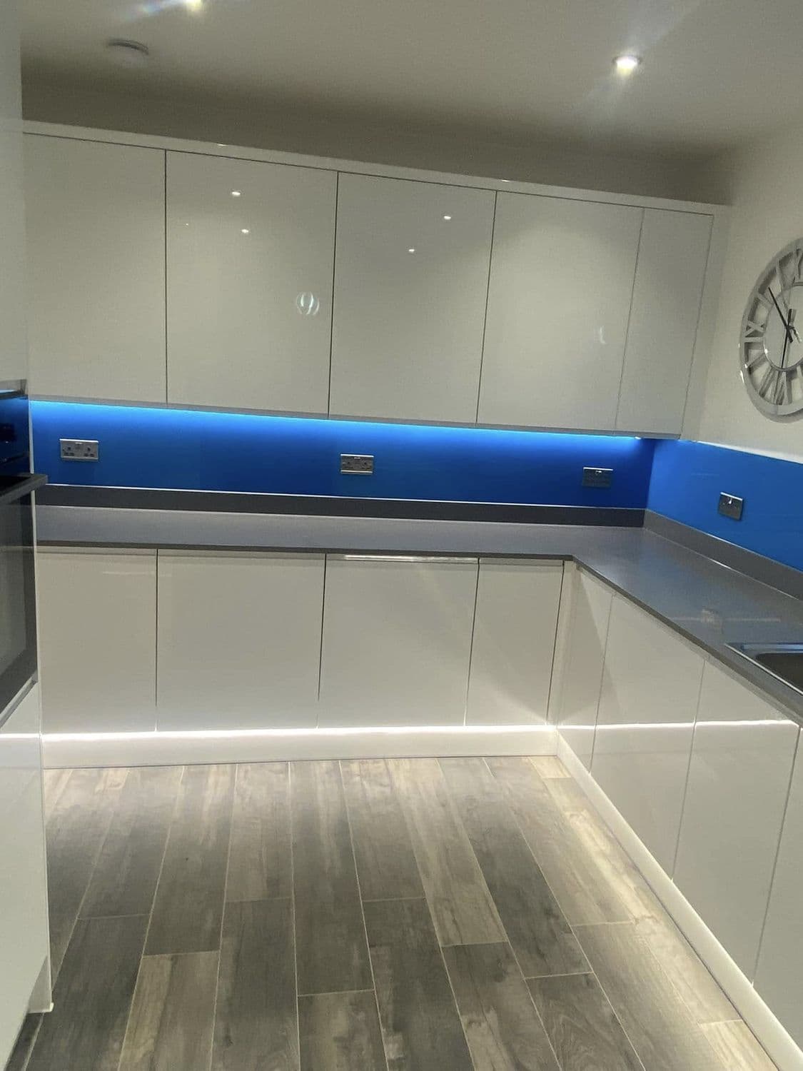 Gloss kitchen with blue LED feature lighting and under-cabinet strips