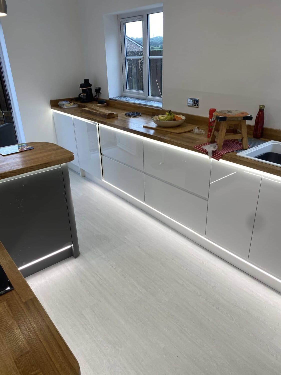Modern kitchen with warm under-cabinet and plinth lighting