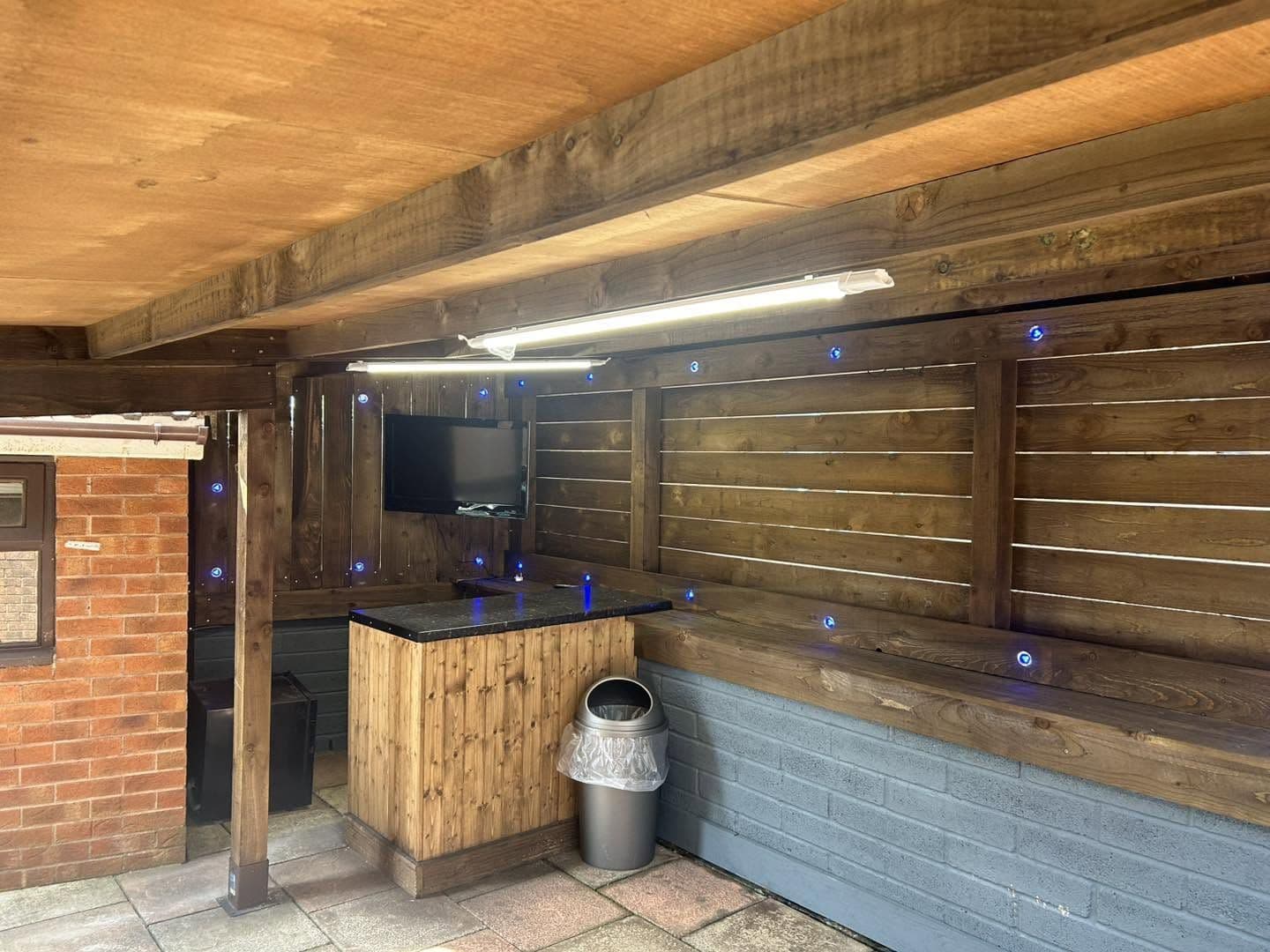 Covered garden bar with downlights and blue feature lighting