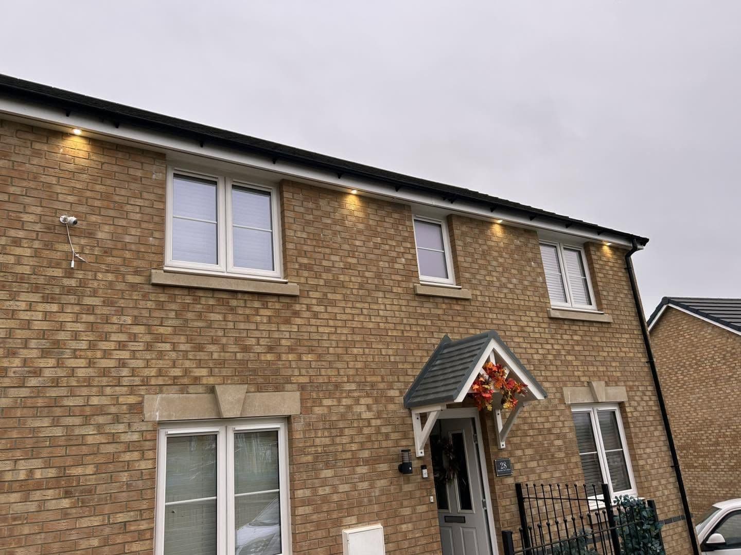 Soffit downlights installed across the front of a new-build home